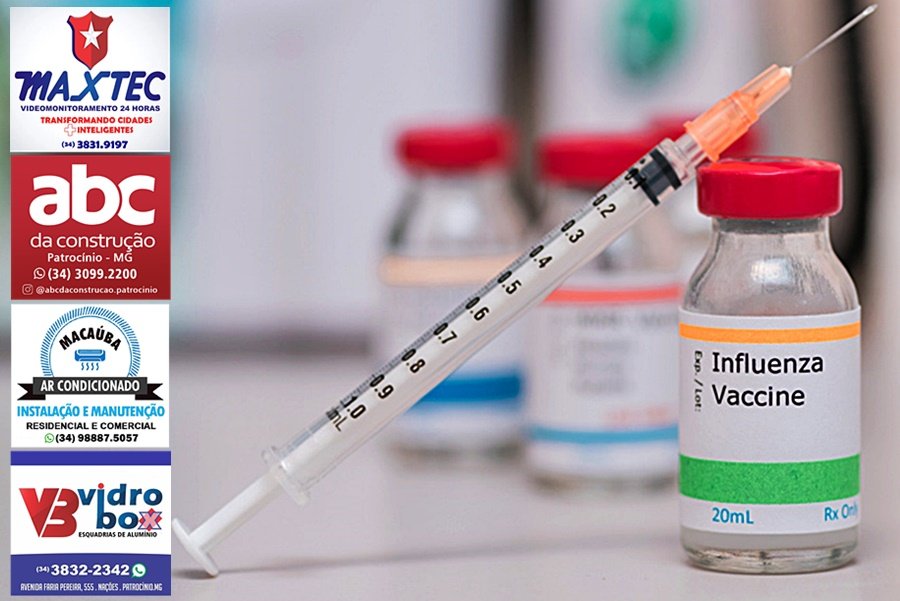 influenza vaccination concept with syringe in vaccine vial and other vials in background